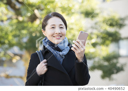 Outdoor mature woman and smartphone Outdoor mature woman and smartphone 40490652