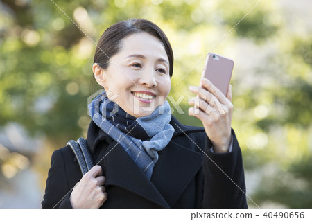 Outdoor mature woman and smartphone Outdoor mature woman and smartphone 40490656