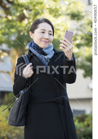Outdoor mature woman and smartphone Outdoor mature woman and smartphone 40490657