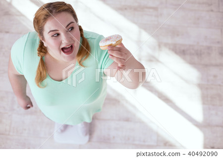 Happy stout woman trying donut 40492090