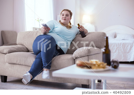 Lazy obese woman drinking beer 40492809