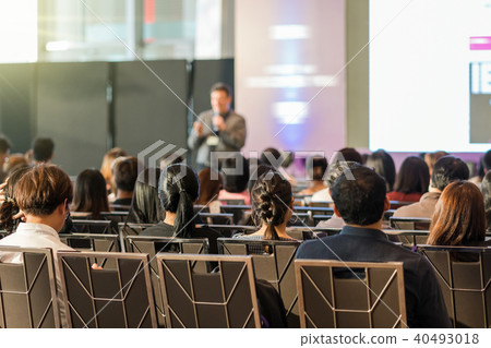 Rear view of Audience in the conference hall or seminar meeting which have speaker in front of the room on the stage, business and education concept Rear view of Audience in the conference hall or seminar meeting which have speaker in front of the room on the stage, business and education concept 40493018