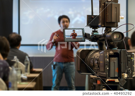 Closeup Video recording the Asian Speaker with casual suit on the stage over the presentation screen in the meeting room of business or education seminar, event and seminar concept 40493292