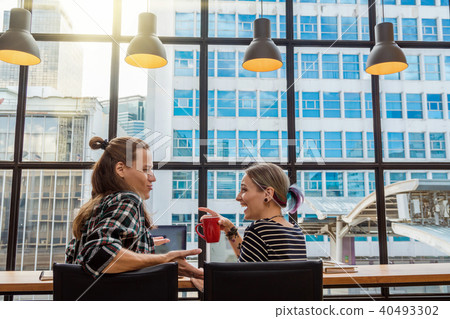 Backside of Hipster young couple freelancer using smart Laptop for working in the Loft cafe workplace. Creative Startup and entrepreneur business concept Backside of Hipster young couple freelancer using smart Laptop for working in the Loft cafe workplace. Creative Startup and entrepreneur business concept 40493302