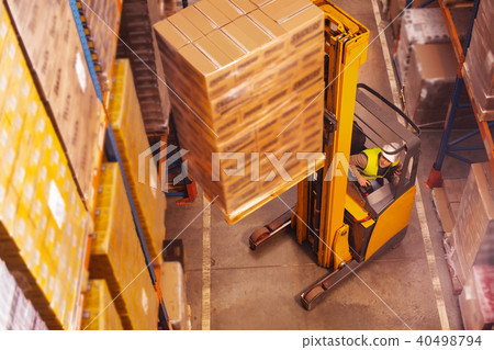 Nice smart man putting boxes of the storage shelf Nice smart man putting boxes of the storage shelf 40498794