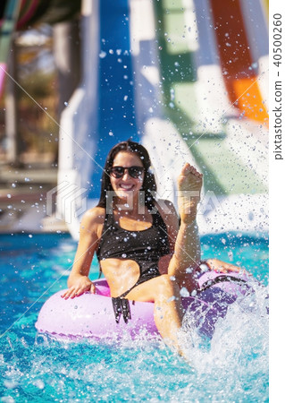 smiling lady in bikini sitting in the pool on rubber ring smiling lady in bikini sitting in the pool on rubber ring 40500260