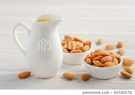 Almond oil and almonds on a white background. Almond oil and almonds on a white background. 40500578