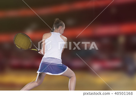 Female tennis player reaching to hit the tennis ball on court 40501168