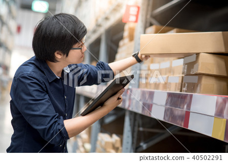 Asian man doing stocktaking in warehouse 40502291