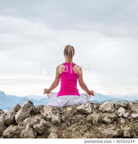 Woman meditating at the lake Woman meditating at the lake 40503234