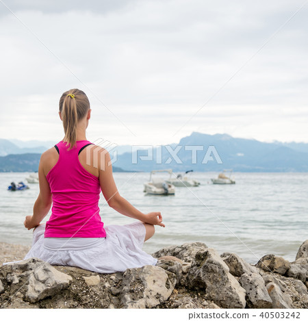 Woman meditating at the lake 40503242