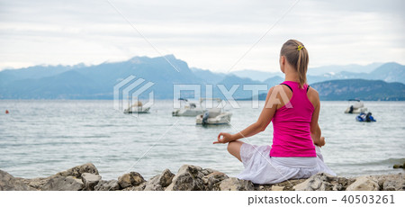 Woman meditating at the lake Woman meditating at the lake 40503261