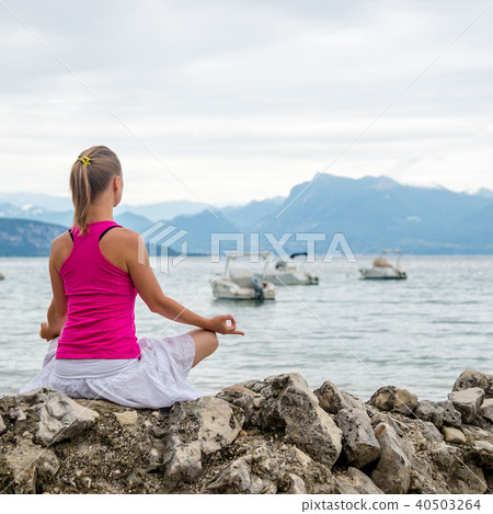 Woman meditating at the lake Woman meditating at the lake 40503264