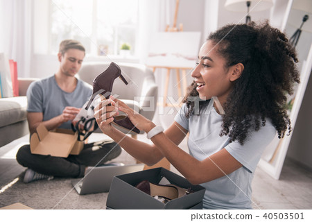 Pleasant cheerful woman looking at the new shoes 40503501