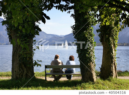Elderly couple sitting on a bench 40504316