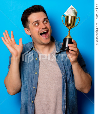man in jeans shirt with golden cup and money 40505137