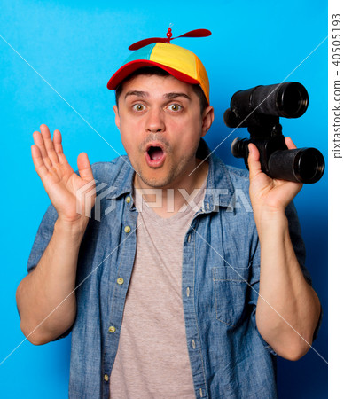 Young nerd man with noob hat using a binoculars 40505193