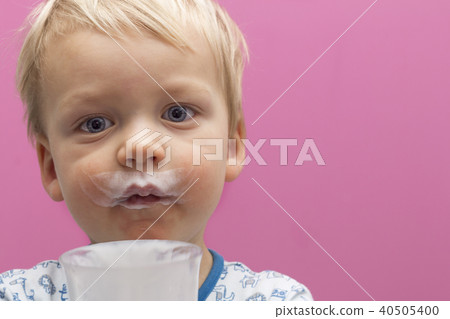 Close-up portrait of cute toddler with sour cream mustache. Copy space 40505400