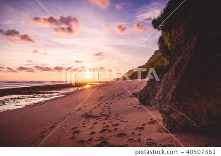 Tropical sandy beach with rocks and sunset 40507361