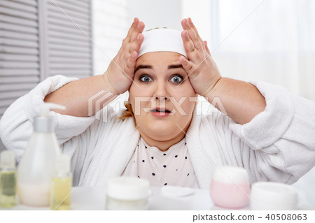 Amazed plump woman touching her face Amazed plump woman touching her face 40508063