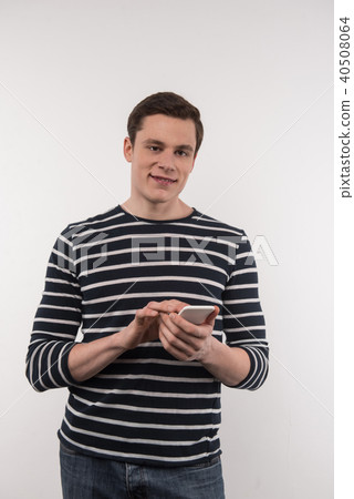 Joyful pleasant man using his smartphone Joyful pleasant man using his smartphone 40508064