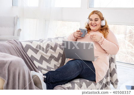 Cheerful overweight woman watching a film Cheerful overweight woman watching a film 40508337