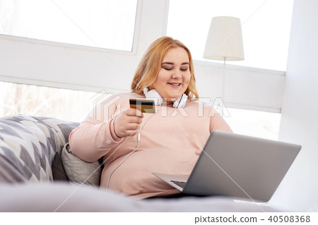 Happy overweight woman holding a credit 40508368
