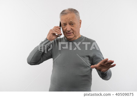 Pleasant elderly man having a phone conversation Pleasant elderly man having a phone conversation 40509075