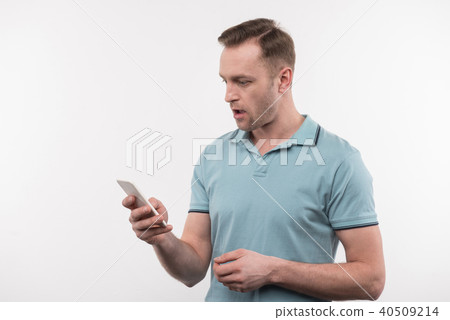 Pleasant nice man looking at his gadget 40509214