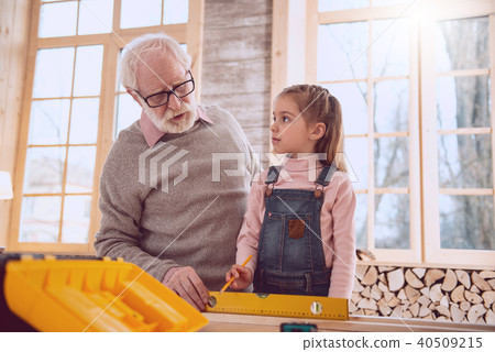 Serious aged man holding a ruler 40509215