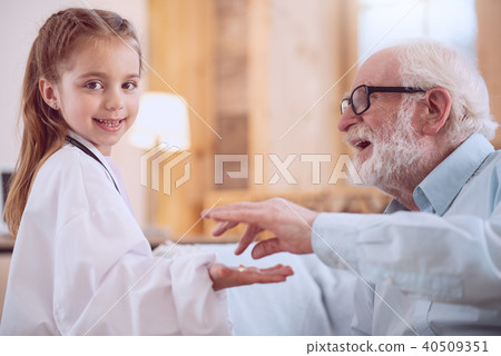 Delighted positive girl giving a pill Delighted positive girl giving a pill 40509351