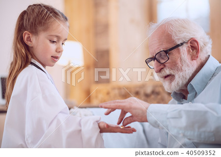 Serious smart girl holding a pill 40509352