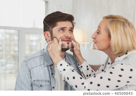 Happy senior woman holding her sons cheeks 40509843