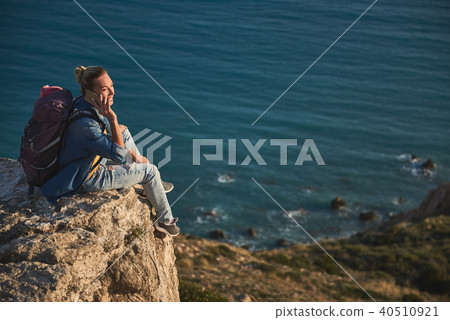 Woman speaking by phone on hill Woman speaking by phone on hill 40510921