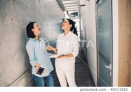 Female executives talking and laughing Female executives talking and laughing 40511082