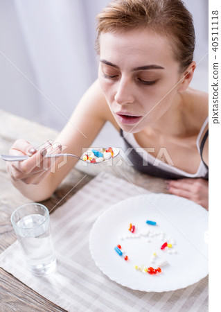 Depressed young woman taking medicine 40511118