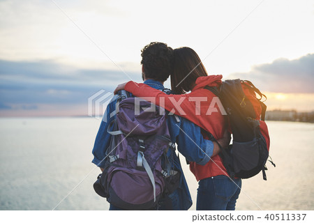 Peaceful man and woman watching sunset at seaside Peaceful man and woman watching sunset at seaside 40511337