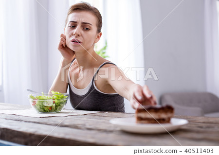 Depressed young woman wanting a cake Depressed young woman wanting a cake 40511403