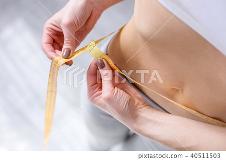 Close up of a centimeter tape around the waist 40511503