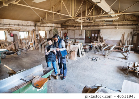 Man and woman workers with tablet in the carpentry workshop. Man and woman workers with tablet in the carpentry workshop. 40511943