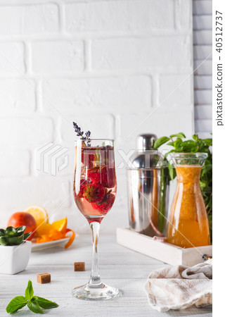Refreshing cocktail with champagne and cranberry with ice, ginger and lavender on wooden background 40512737