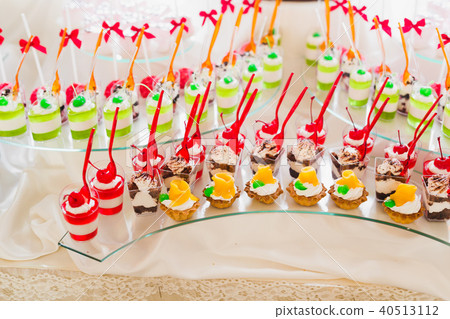 Delicious sweets on wedding candy buffet with desserts, cupcakes Delicious sweets on wedding candy buffet with desserts, cupcakes 40513112