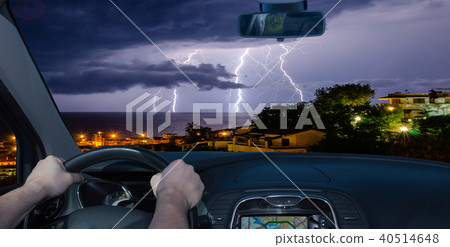 Driving towards a lightning storm over the sea 40514648