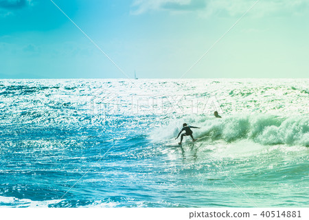 Surfers riding some waves on the sea 40514881