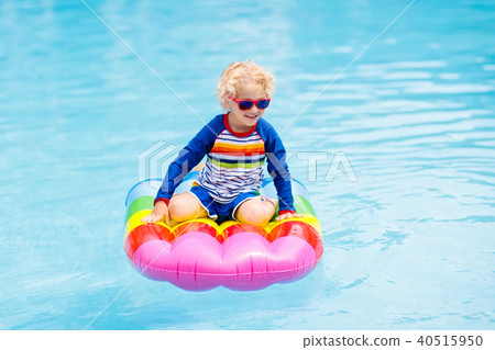 Child on inflatable float in swimming pool. Child on inflatable float in swimming pool. 40515950