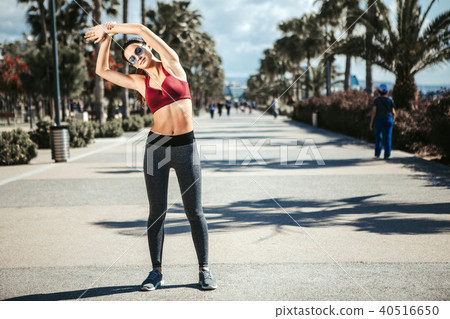 Serene young woman doing morning exercise outdoor 40516650