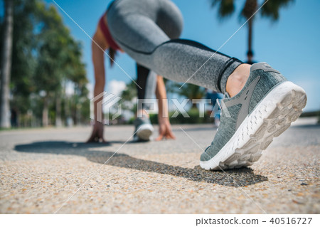 Active young woman standing at start position before running 40516727