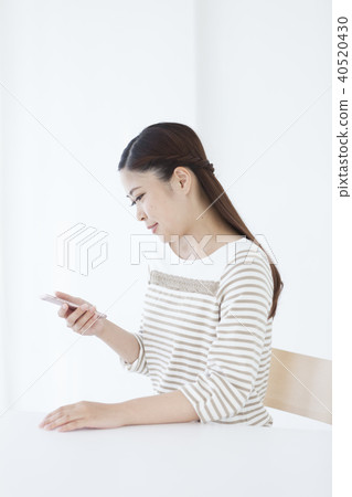 A Japanese woman operating a smartphone 40520430