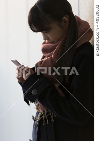 Schoolgirl looking at a smartphone Schoolgirl looking at a smartphone 40520632