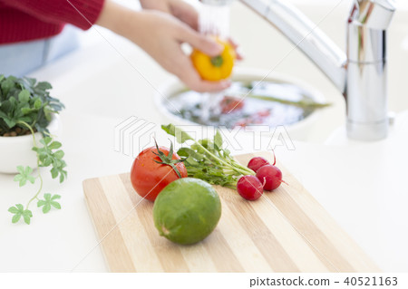 Woman washing vegetables Woman washing vegetables 40521163